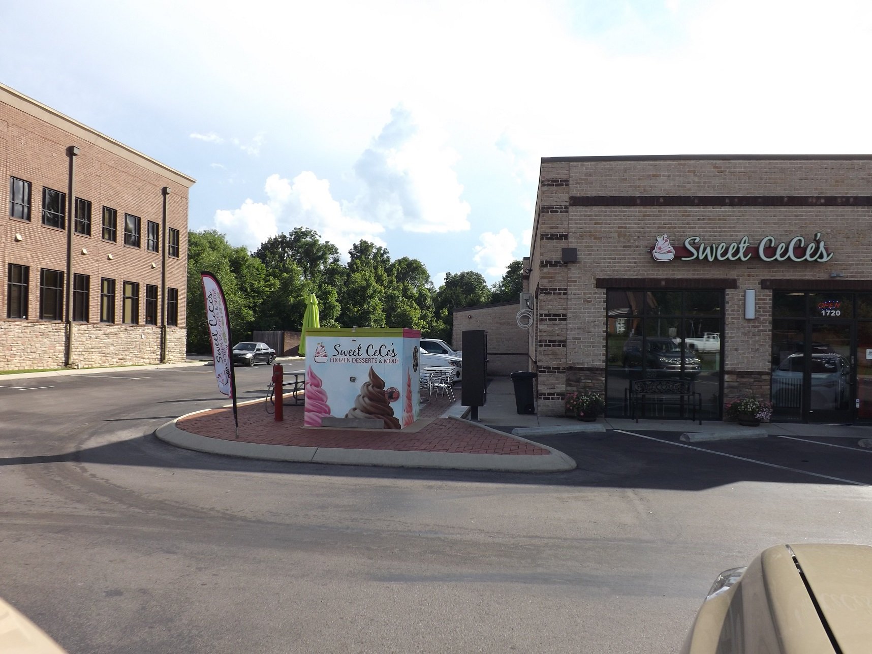 An aluminum enclosure hidden by a brightly colored vinyl wrap advertisement for a local dessert shop.