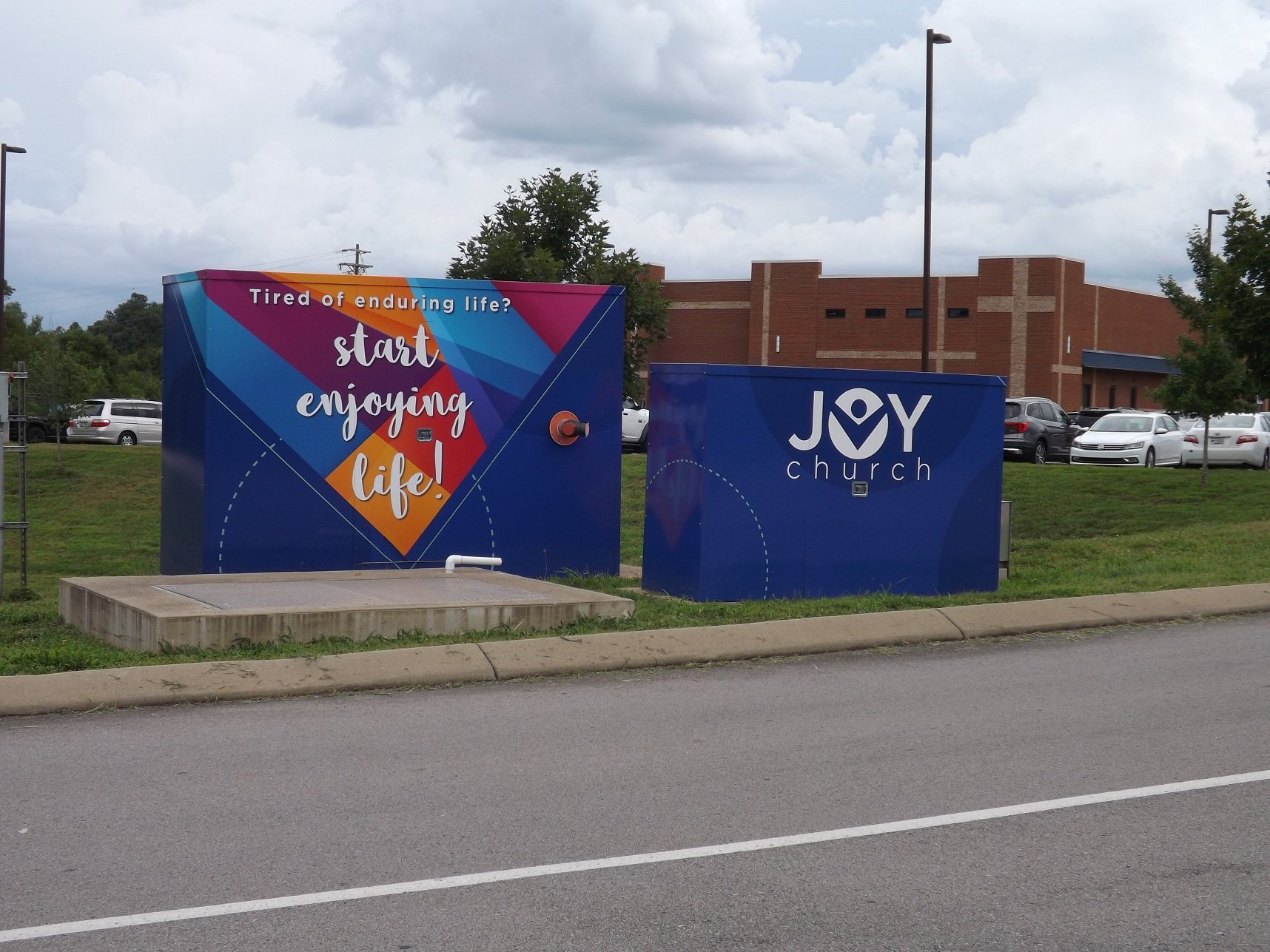 Two enclosures side by side in brilliant blue color with a church logo and church motto painted in brilliant shades of colors.