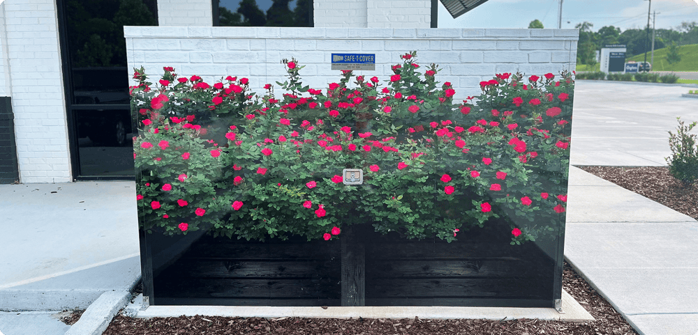 A vinyl wrap helps this Safe-T-Cover enclosure blend in with the white brick building behind it.