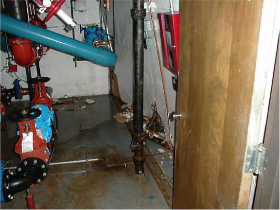 A hospital's flooded and damaged mechanical room after an RPZ water discharge event