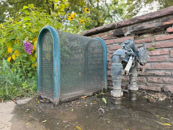 A backflow cage was vandalized in Denver. The cage was removed and the backflow preventer's pipe was cut causing the unit to be inoperable and leak water.