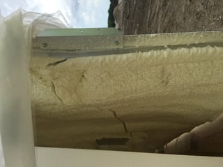 An image of cracked insulation in a sealed area of an aluminum enclosure.