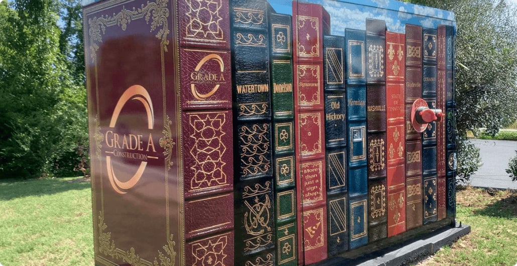A custom vinyl wrap on an enclosure that makes the enclosure appear like a shelf of books