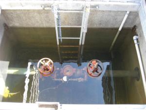 An image of backflow prevention assemblies inside a vault which represents improper backflow preventer installation. For proper backflow preventer installation the reduced pressure backflow assembly should be installed in an aluminum enclosure. This ensures the reduced pressure backflow assembly offers optimal supply pressure to the backflow prevention device 